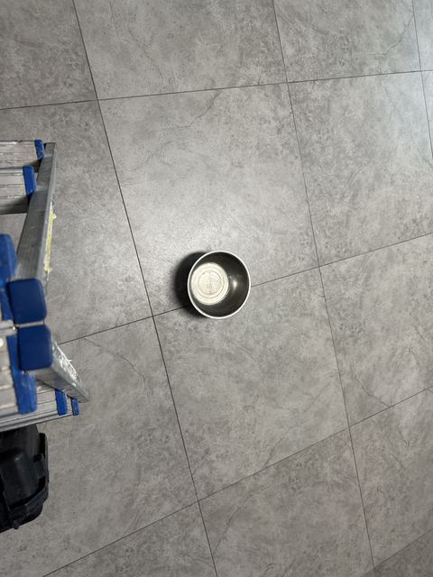사다리 옆 타일 바닥 그릇 안쪽에 물기가 비치는 모습