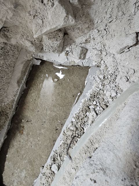 마감을 깨어 낸 바닥 아래 콘크리트 홈에 고인 물과 옆의 배관
