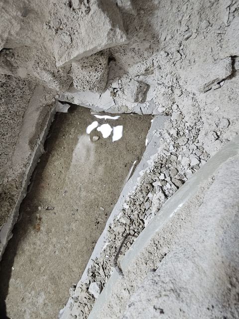 개방한 바닥 속 빛이 반사되는 고인 물과 주변 몰탈 부스러기