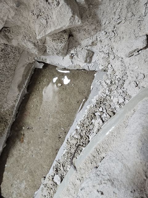 깨어 낸 바닥 홈의 물웅덩이와 오른쪽 배관 옆에 쌓인 몰탈 부스러기