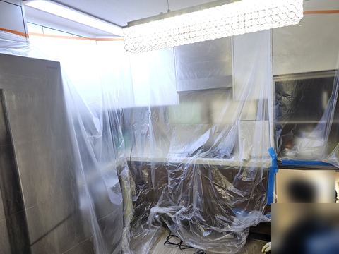 냉장고와 싱크대를 비닐로 덮고 테이프로 고정한 주방 전경