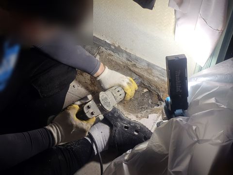 열어 둔 바닥 가장자리를 그라인더로 갈아 내는 작업자
