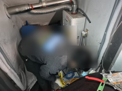 좁은 보일러실에서 몸을 숙여 바닥 배관에 파랑·노랑 선을 잇는 뒷모습