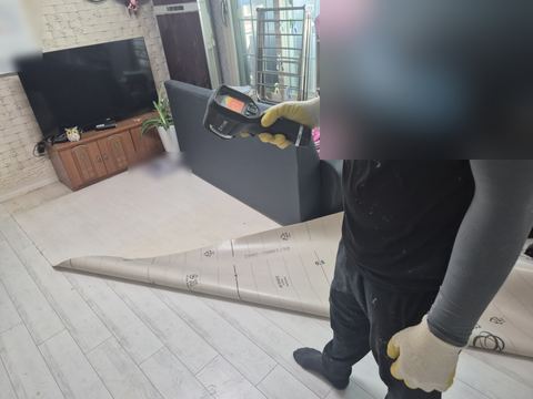 말려 올라간 거실 장판 옆 바닥에 열화상 카메라를 향한 작업자